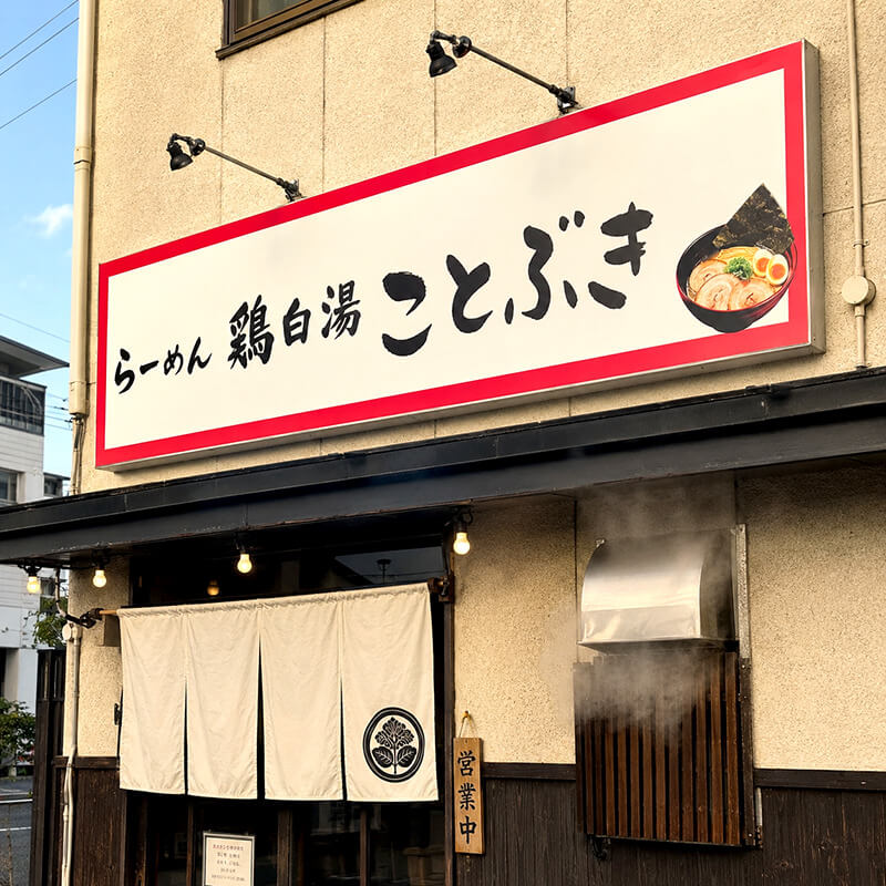 らーめん 鶏白湯 ことぶきのプレート看板。赤枠の中に毛筆風文字