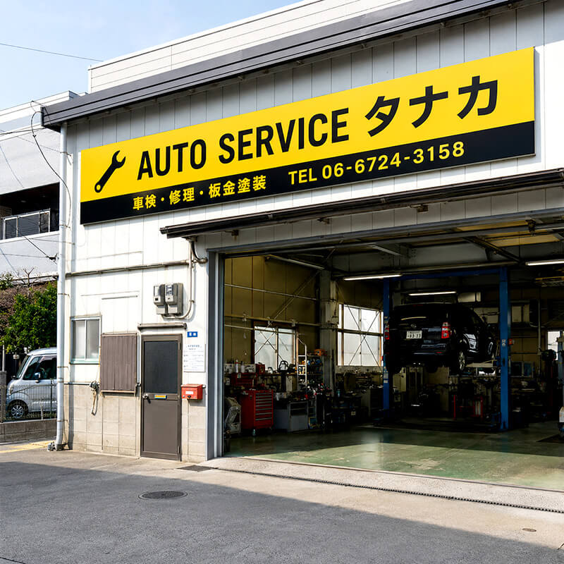 AUTO SERVICE タナカの大型プレート看板。黄色と黒のインパクト