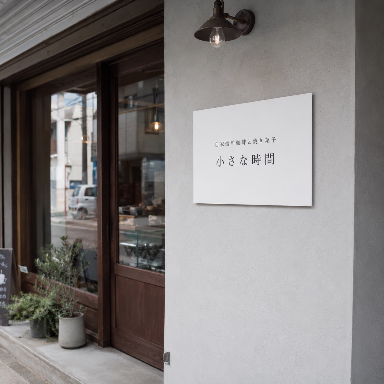 白いプレート看板が設置された小さなカフェの外観。コスパが良く小規模店舗でも導入しやすいことを示す事例